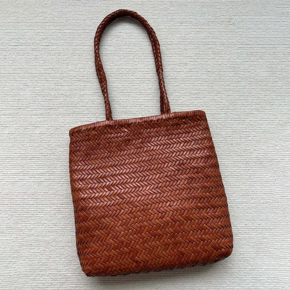Brown vintage woven leather tote bag with a three-dimensional front pocket.