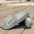 Women's grey blue flip-flop slippers with a silver adjustable buckle on the strap.