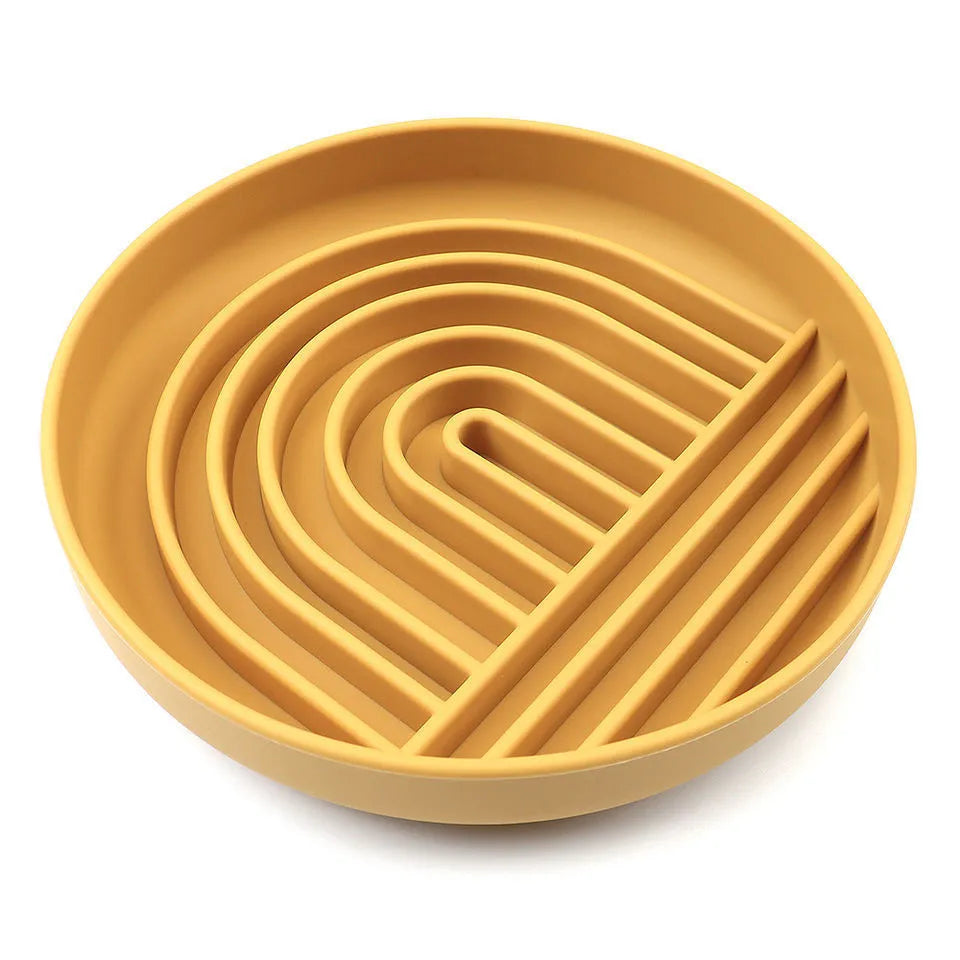 Silicone slow feeder dog bowl with ridges in various colours on a table.