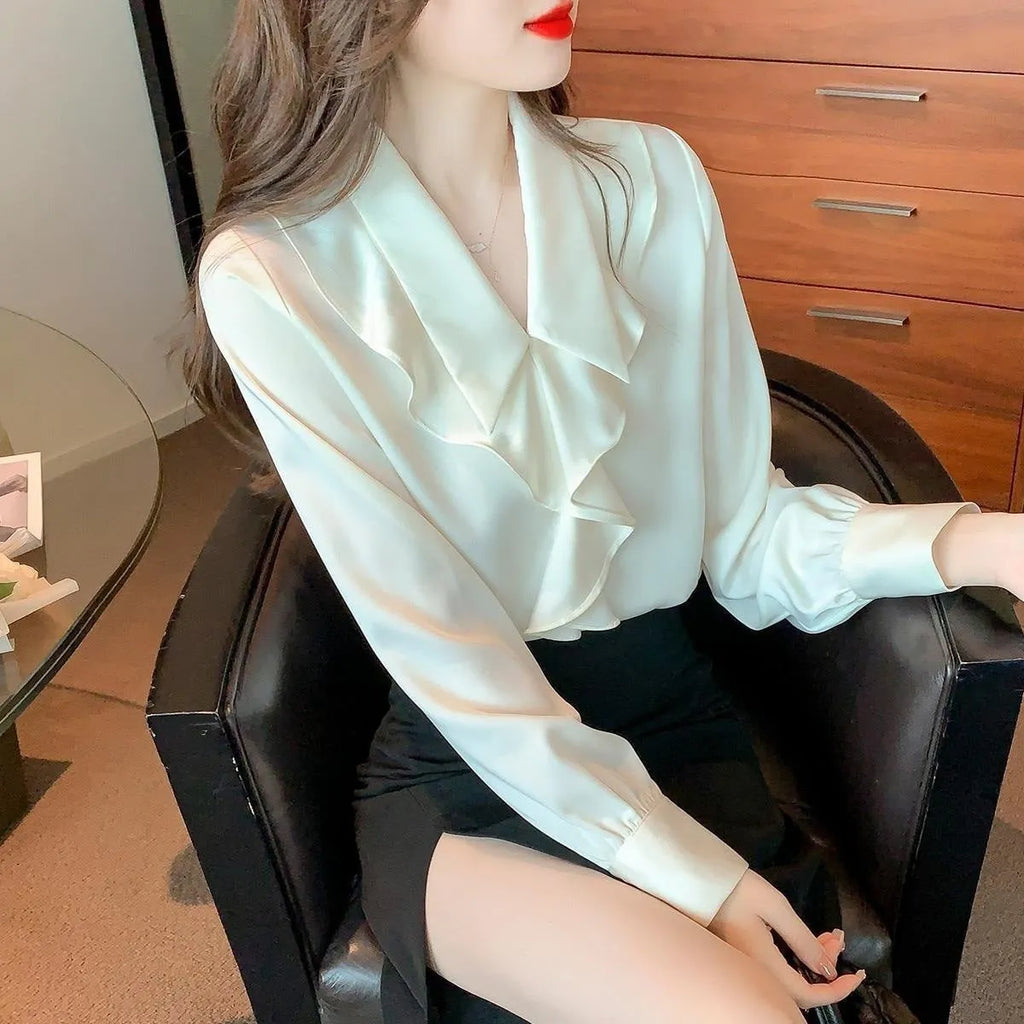 Ladies white chiffon blouse with long sleeves on a plain background