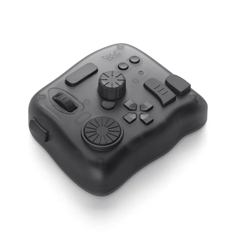 TourBox NEO video editing controller and auxiliary keyboard on a desk, showing its dials, buttons, and compact black design.