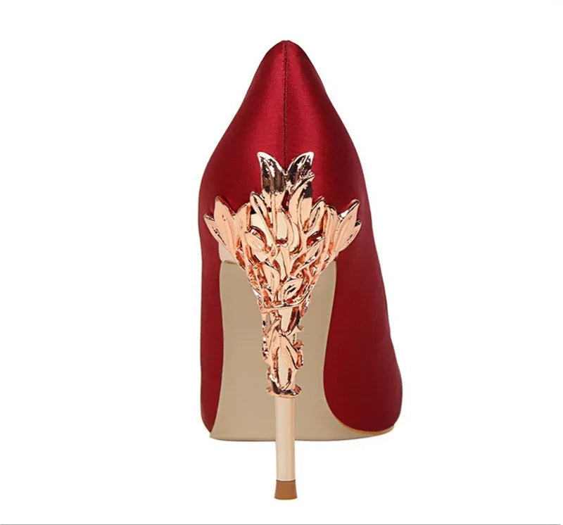 Pointy silver satin stiletto heels with 10cm heel and 1cm platform on neutral background