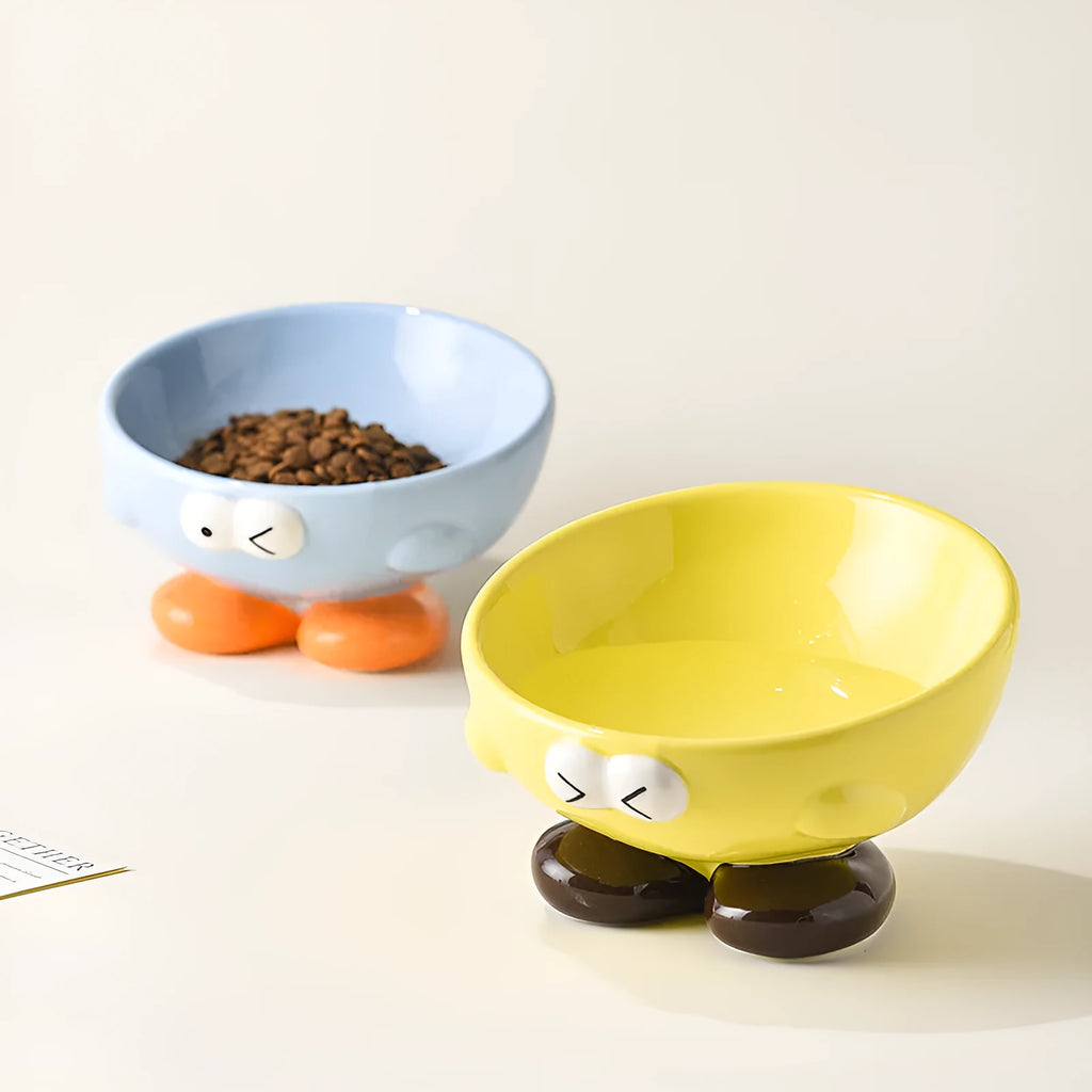 Oblique ceramic pet bowl with cute expression pattern, tall design for cervical spine protection