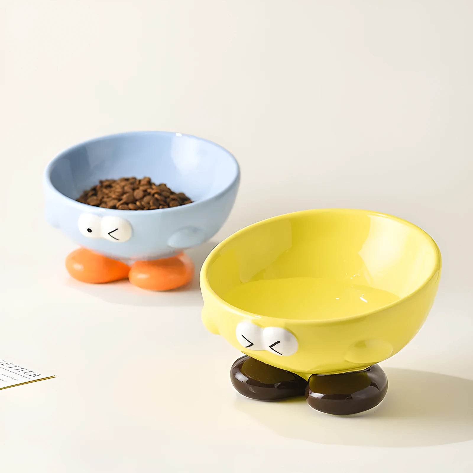 Oblique ceramic pet bowl with cute expression pattern, tall design for cervical spine protection
