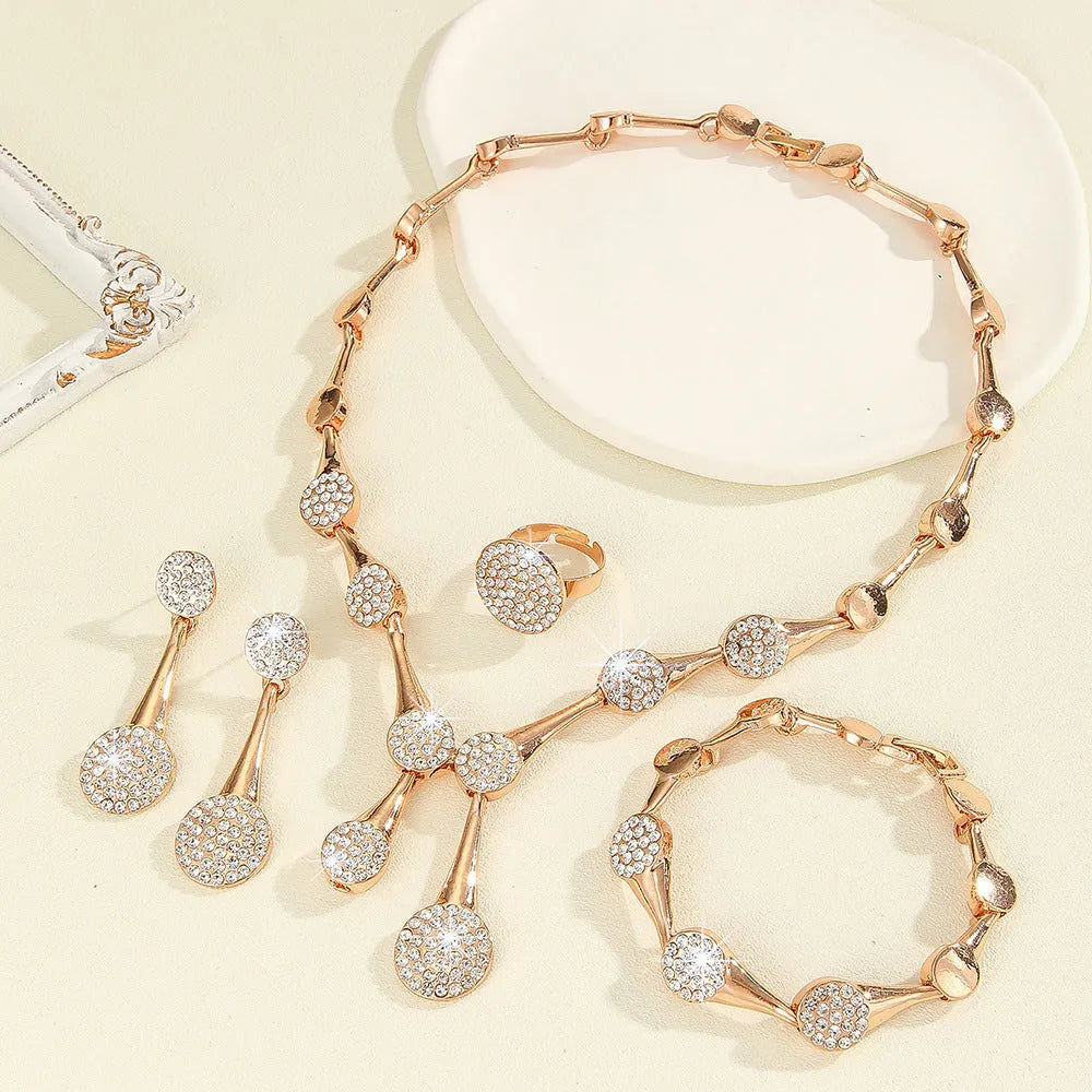 Gold alloy necklace earrings and bracelet set with bow and fan motifs on a light background