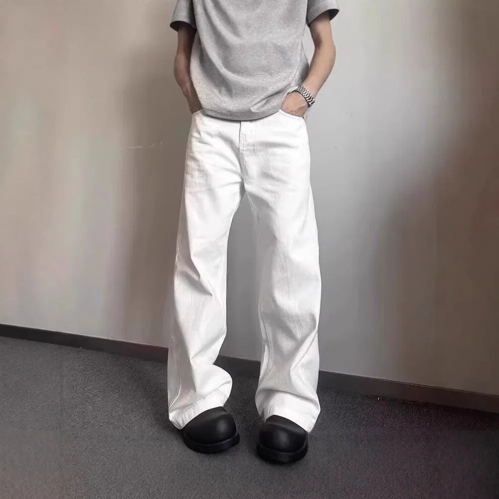 Men's white straight-leg denim jeans with a wide fit and mid-rise waist on a plain background.