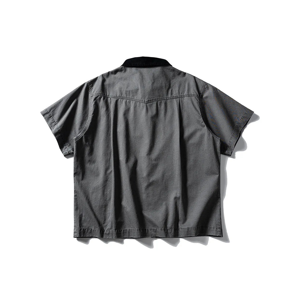A khaki washed cotton overalls shirt with short sleeves and a loose cardigan style, laid flat.