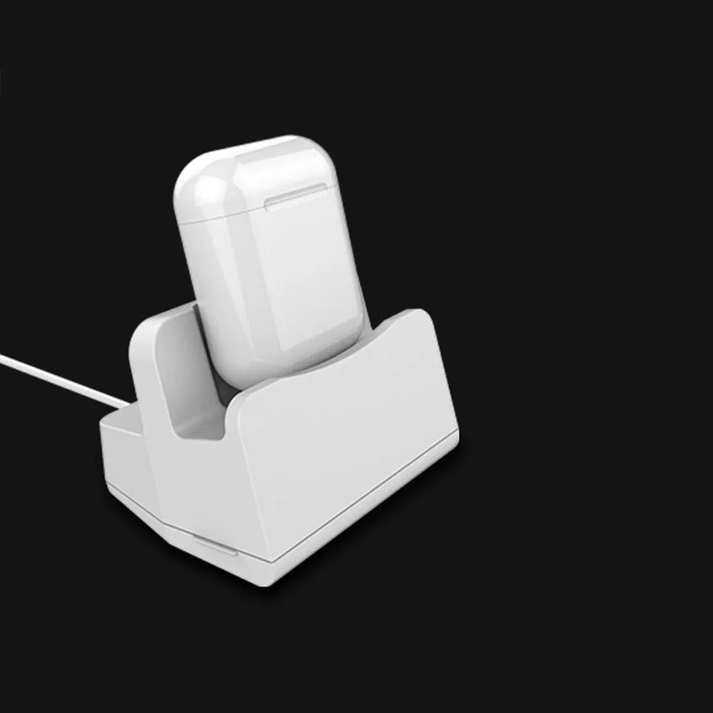 White plastic headphone charging base for wireless earbuds on desk