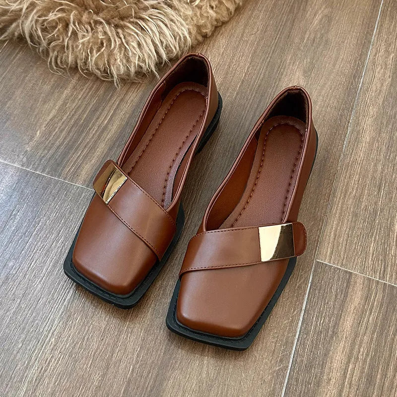 Beige women's square-toe flat shoes with a metal buckle and low rubber sole.
