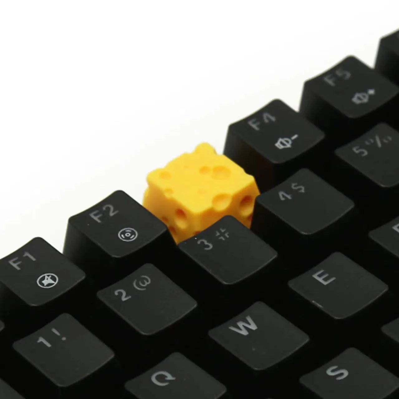 Yellow resin mechanical keyboard keycap sculpted like a wedge of Swiss cheese.