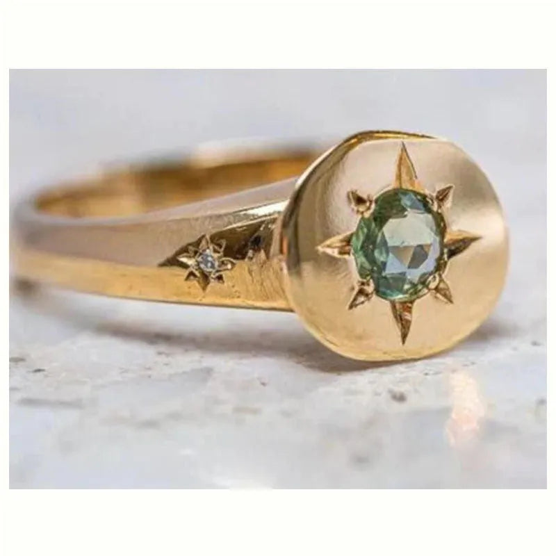 Gold coloured adjustable ring with oval star shape and central asterism zircon stone.
