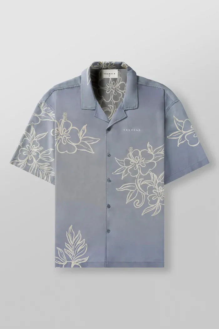 Man wearing a loose, short-sleeved printed floral top in a light colour.
