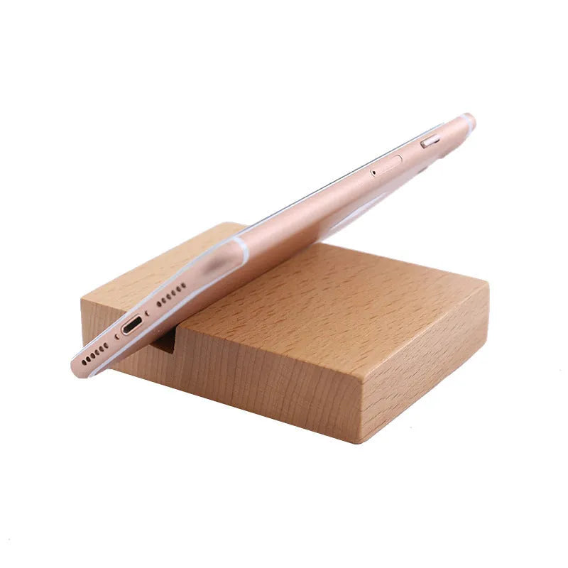 Solid beech wood phone stand with a decorative resin puppy figurine, holding a mobile phone at an angle with a charging cable threaded through the back.
