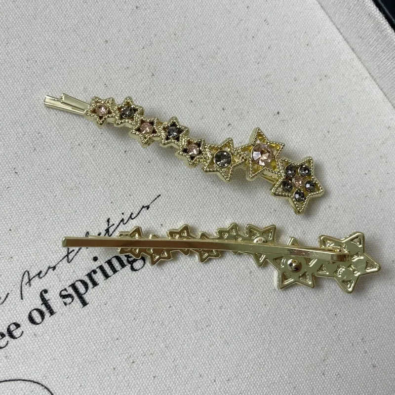 Gold-coloured alloy hair barrette with a rhinestone five-pointed star, shown as a side clip.