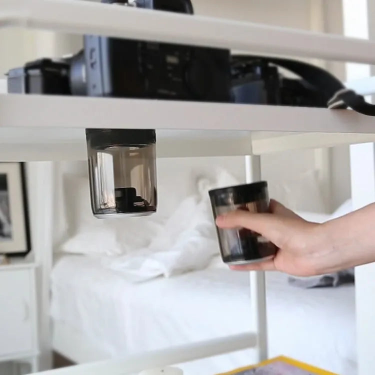 Transparent Bluetooth speaker with black housing and suction cup base on a glass table