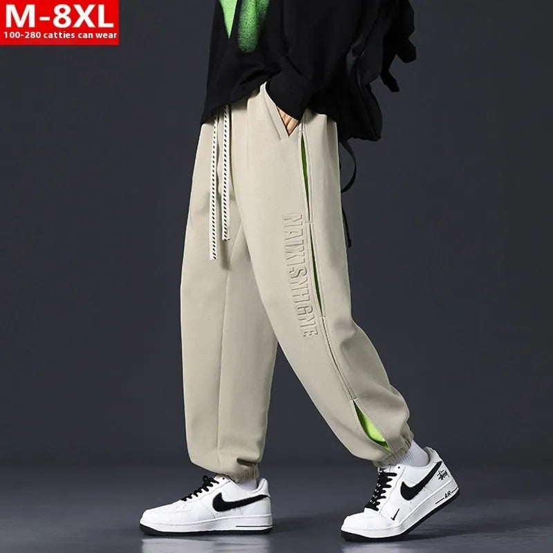 Man wearing loose-fit black trousers with printed stitching detail and a banded ankle cuff.