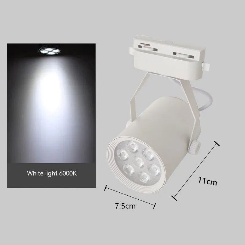 Black and white aluminium LED track spotlight on a lighting track, aimed at a display.