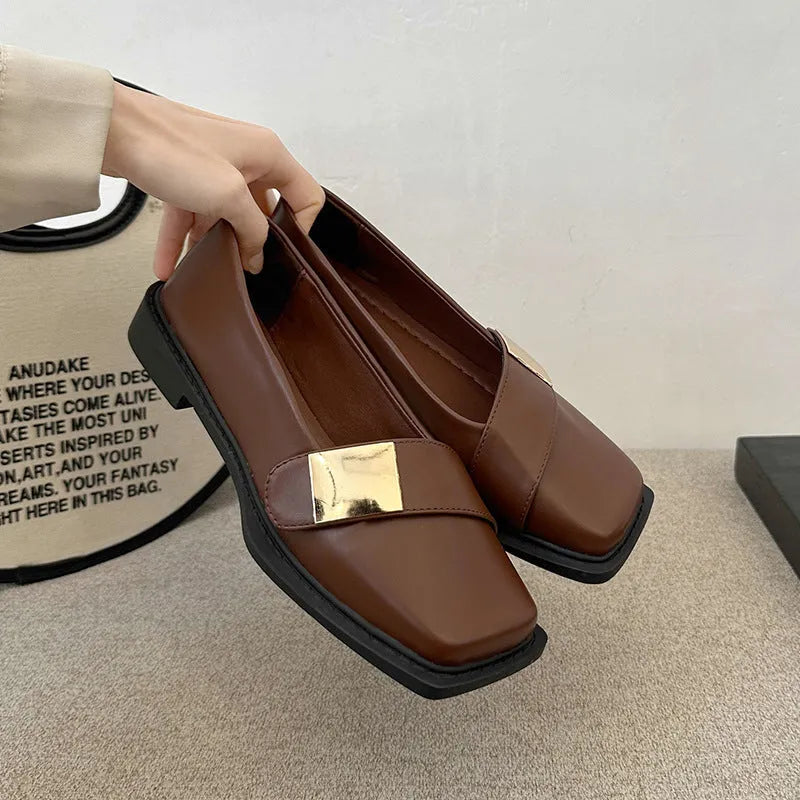 Beige women's square-toe flat shoes with a metal buckle and low rubber sole.