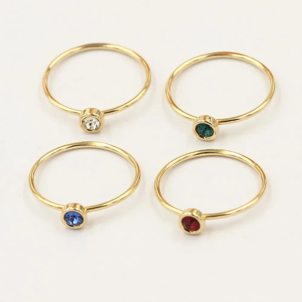 Women's copper knuckle ring with 14K gilding and zircon stones in green, blue, dark red, or white.