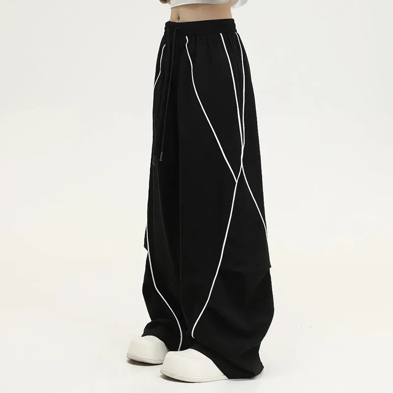 Black striped pleated hip-hop wide-leg sports pants on a hanger.