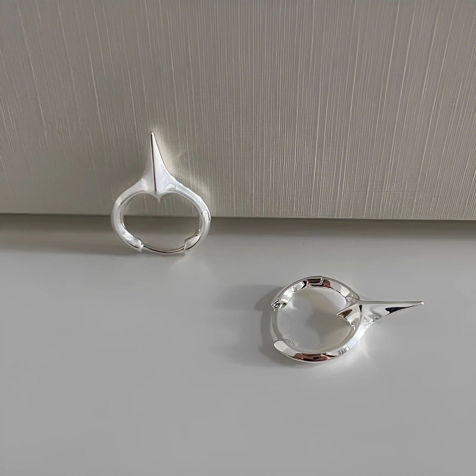 Women's geometric star-shaped clip earrings with a platinum electroplated finish on copper.