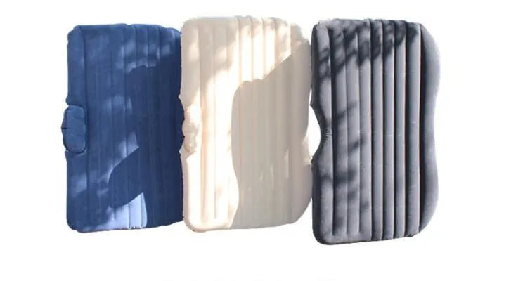 Inflatable car bed with flocking material shown in vehicle with two pillows and storage bag