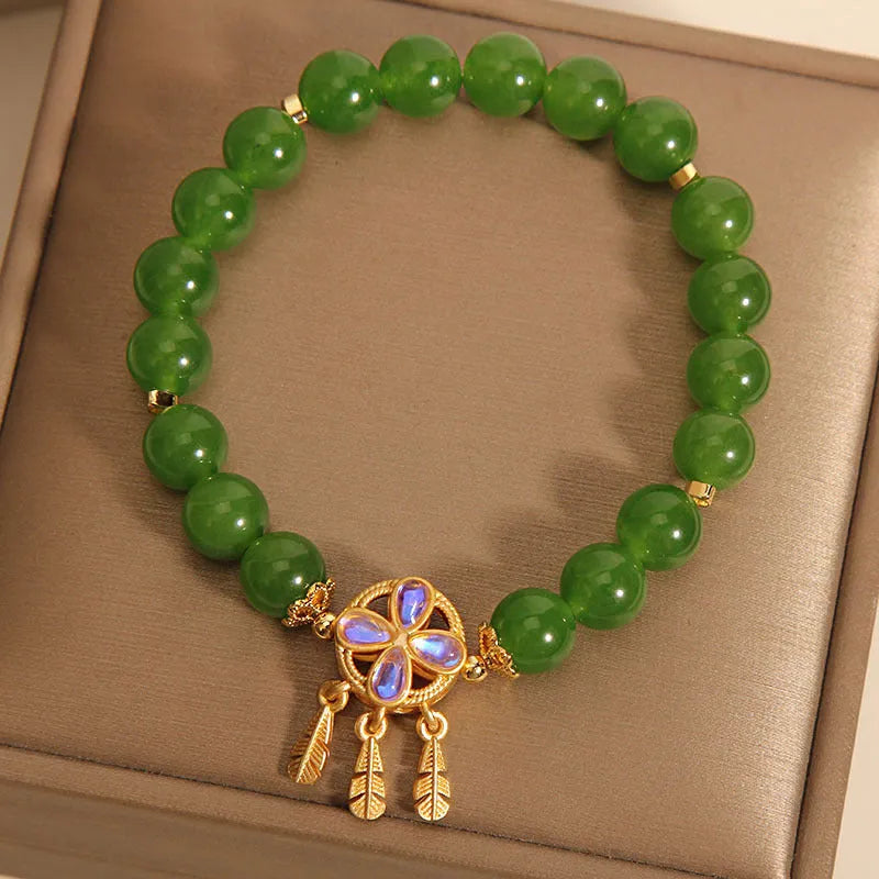 Green jasper crystal four-leaf clover dream catcher pendant on an adjustable women's bracelet.