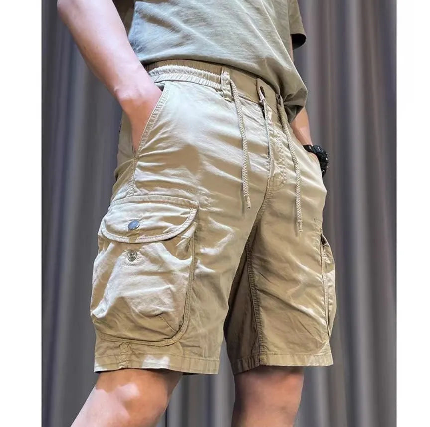 Man wearing loose straight-leg khaki overalls with multiple pockets, showcasing the Korean-style relaxed fit.