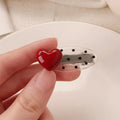 Red stereo love heart-shaped hairpin with French retro dots and willow leaf decoration on a white background.