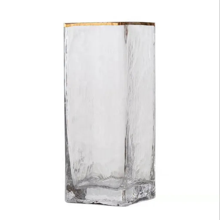 Transparent gold-painted glass vase on plain background