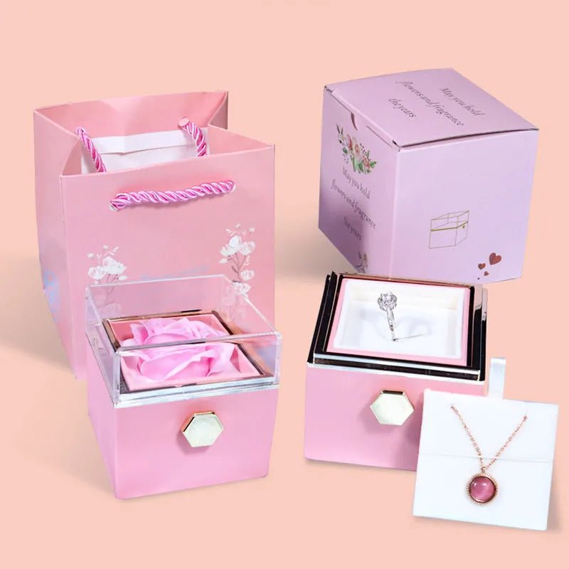 Rotating jewellery gift box with a preserved red rose under a clear acrylic dome.