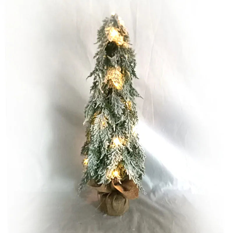 Small 24-inch white artificial Christmas tree with lights and snow spray on a desktop