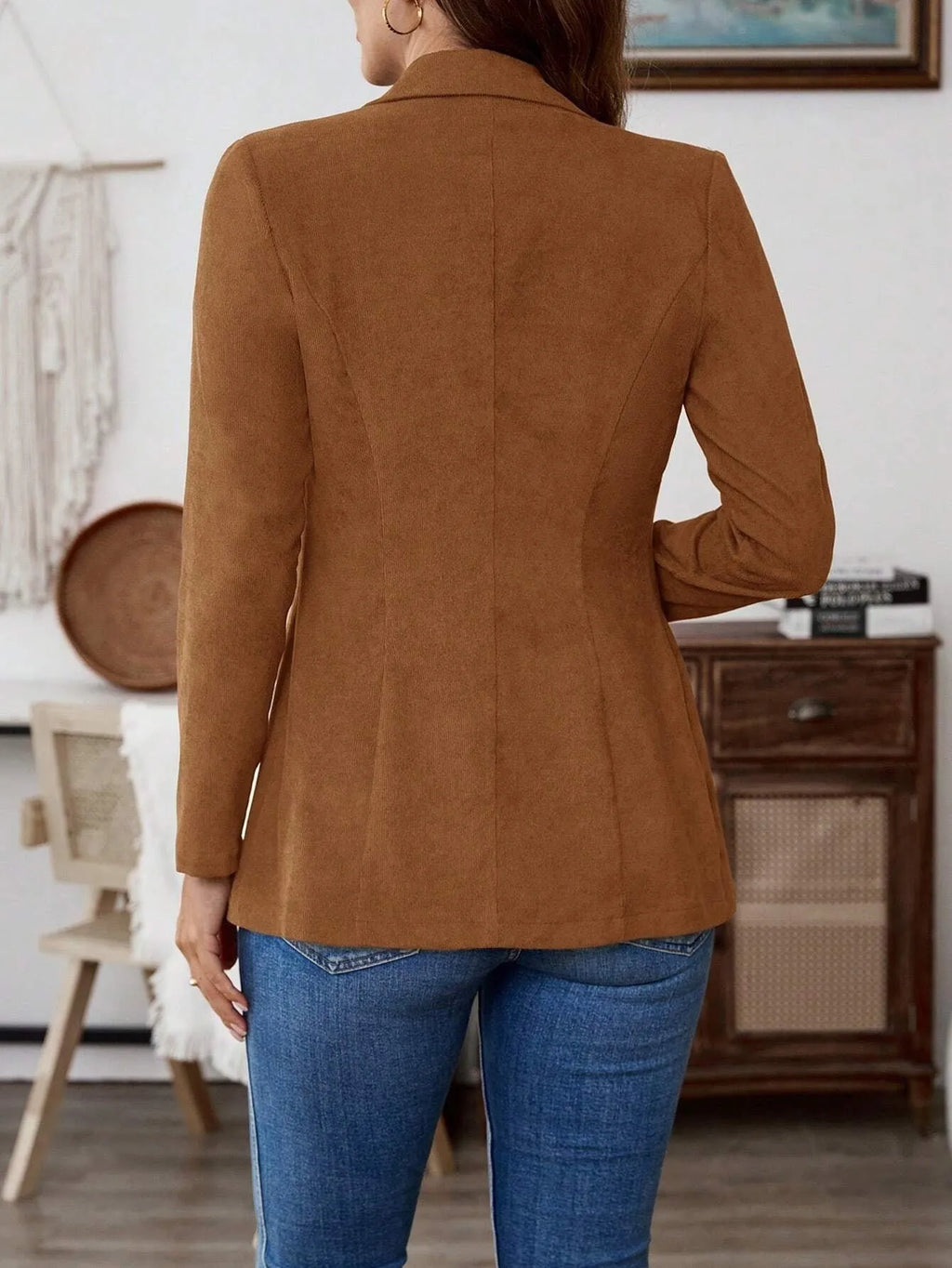 Brown men's single-breasted lapel coat with long sleeves on a hanger.