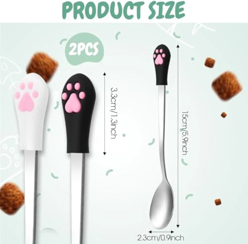 Two stainless steel pet food spoons with silicone grips, one white and one black, featuring a cat paw print.