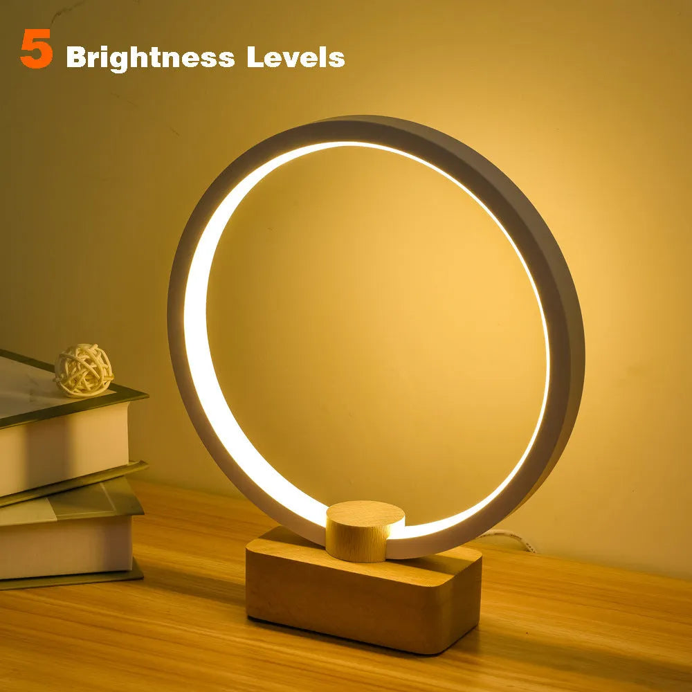 Round small solid wood and bamboo USB-powered LED night lamp on a table.