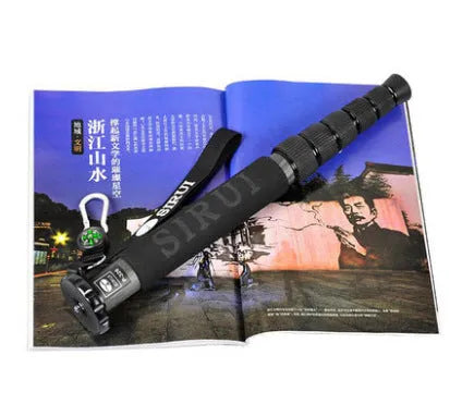 Black carbon fibre telescopic camera monopod fully extended next to an SLR camera