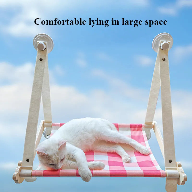 Green wooden cat window hammock with suction cups attached to glass, showing a removable linen mat.
