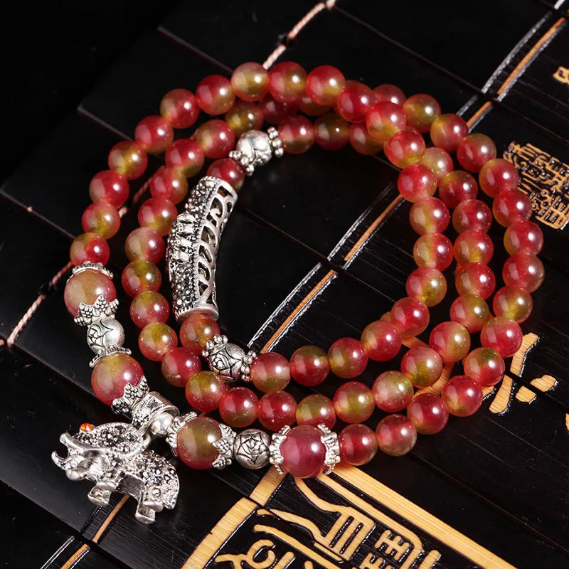 Handcrafted watermelon crystal bracelet with Chinese knot design showing 8mm elephant-style beads