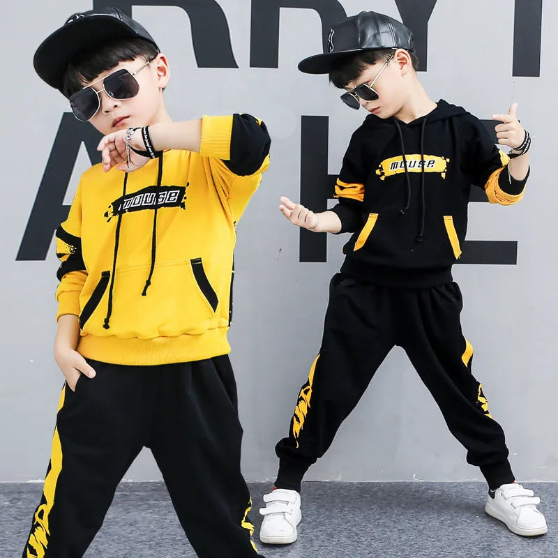 A boy wearing a black Korean-style hooded cotton tracksuit set with a letter print, featuring long sleeves and matching trousers.