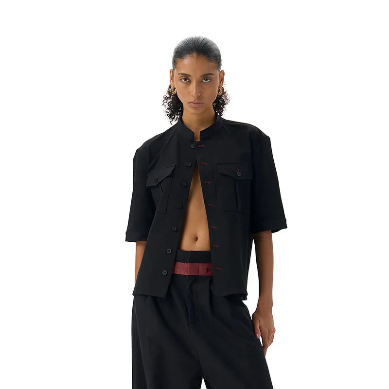 Handmade black half-sleeve hunting shirt with a shirt collar and single-breasted placket on a hanger.