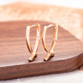 Rose gold cross shaped earrings with a polished finish on a solid copper base.