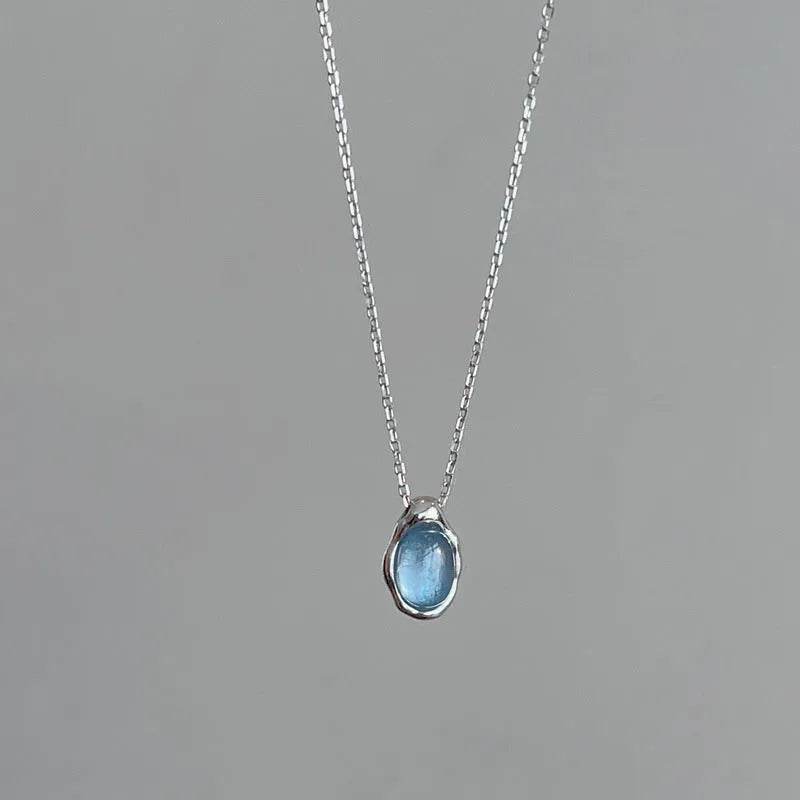 Geometric navy blue water drop pendant necklace on an adjustable copper cross chain for women.