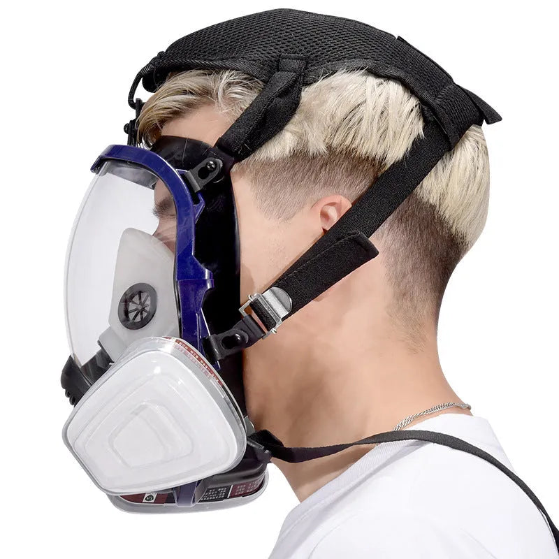 Blue-edged spherical full-face silicone gas mask with trapezoidal filter canister and box of seven filters.