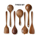 7-piece wooden kitchen utensil set with spoons and spatula on a table.