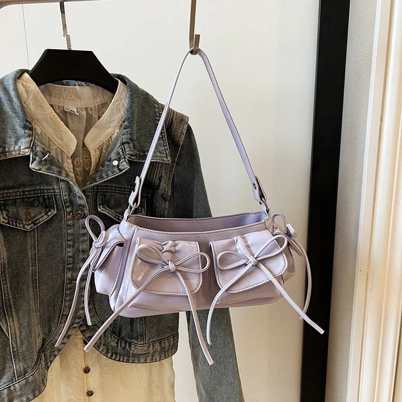 Women's large shoulder bag with bow and tassel decoration, showing multi-pocket sandwich pocket design.