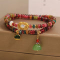 Rainbow tourmaline abacus beads double ring bracelet with lotus seedpod and flower shapes, on white background
