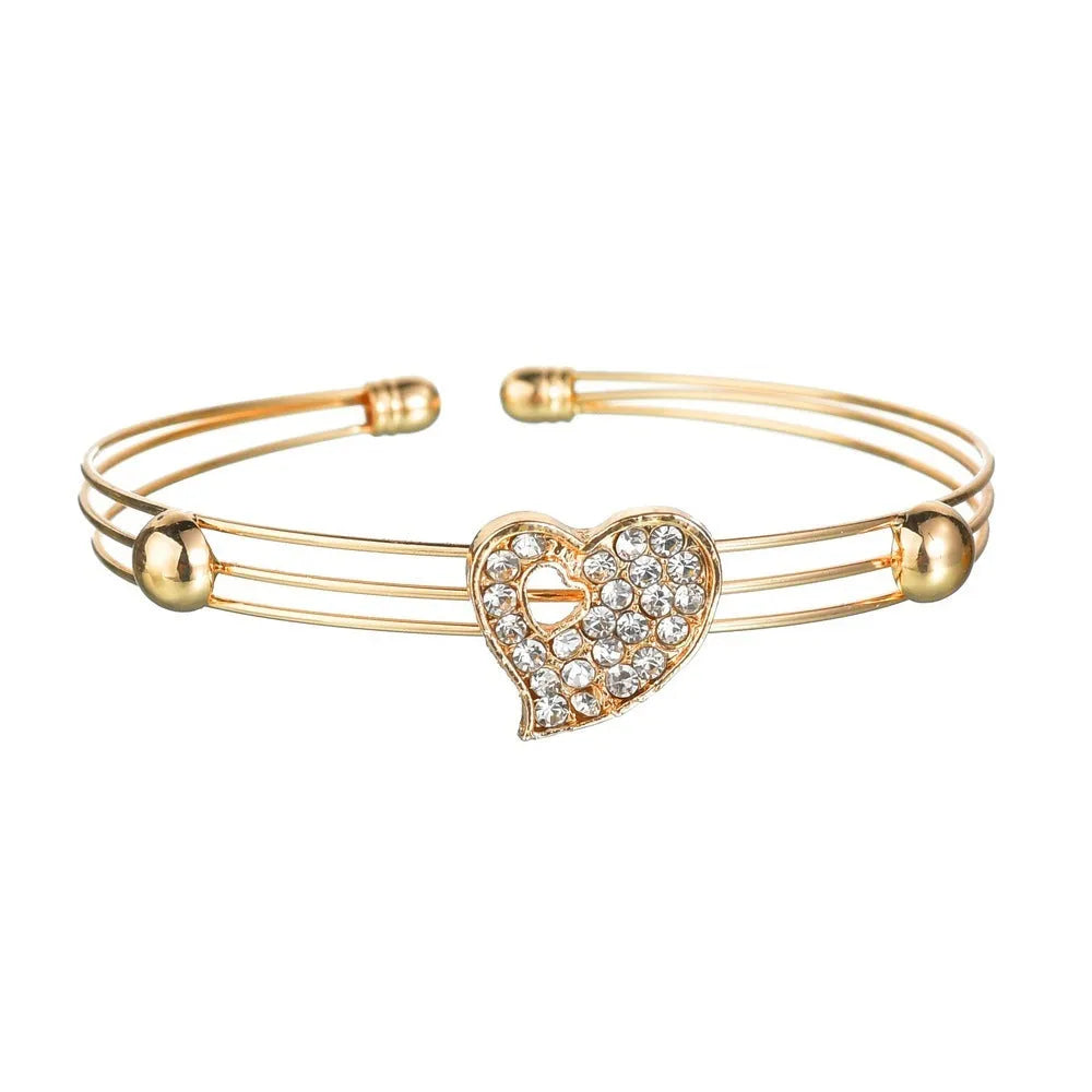 Women's gold tone alloy jewelry set with matching earrings, pendant and bracelet featuring love patterns