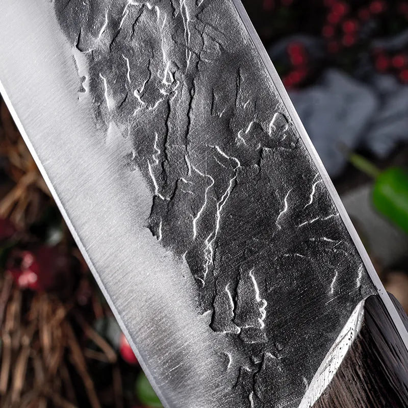 Hand forged stainless steel butcher knife with chicken wing wood handle and copper nails on a cutting board