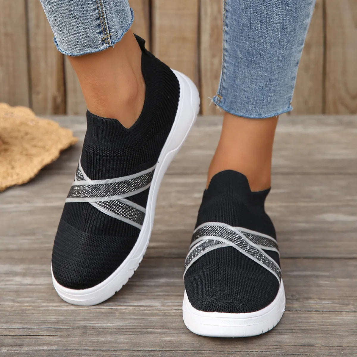 Black women's low-top flyknit mesh flat shoes with round toe and tassel detail on a rubber sole.