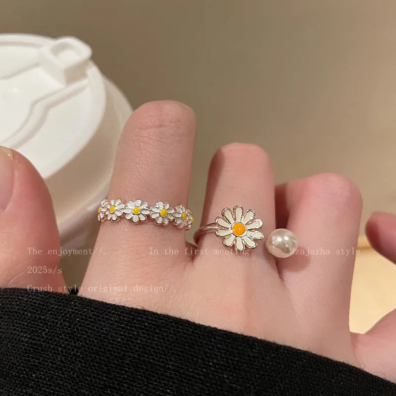 Women's copper opening ring with floral daisy charm and pearl accents on finger